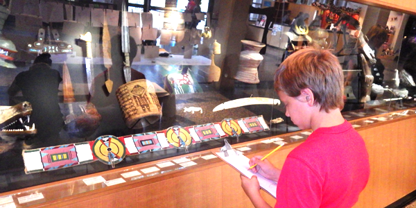 Austin sketching a samurai mask during art day at a Seattle museum